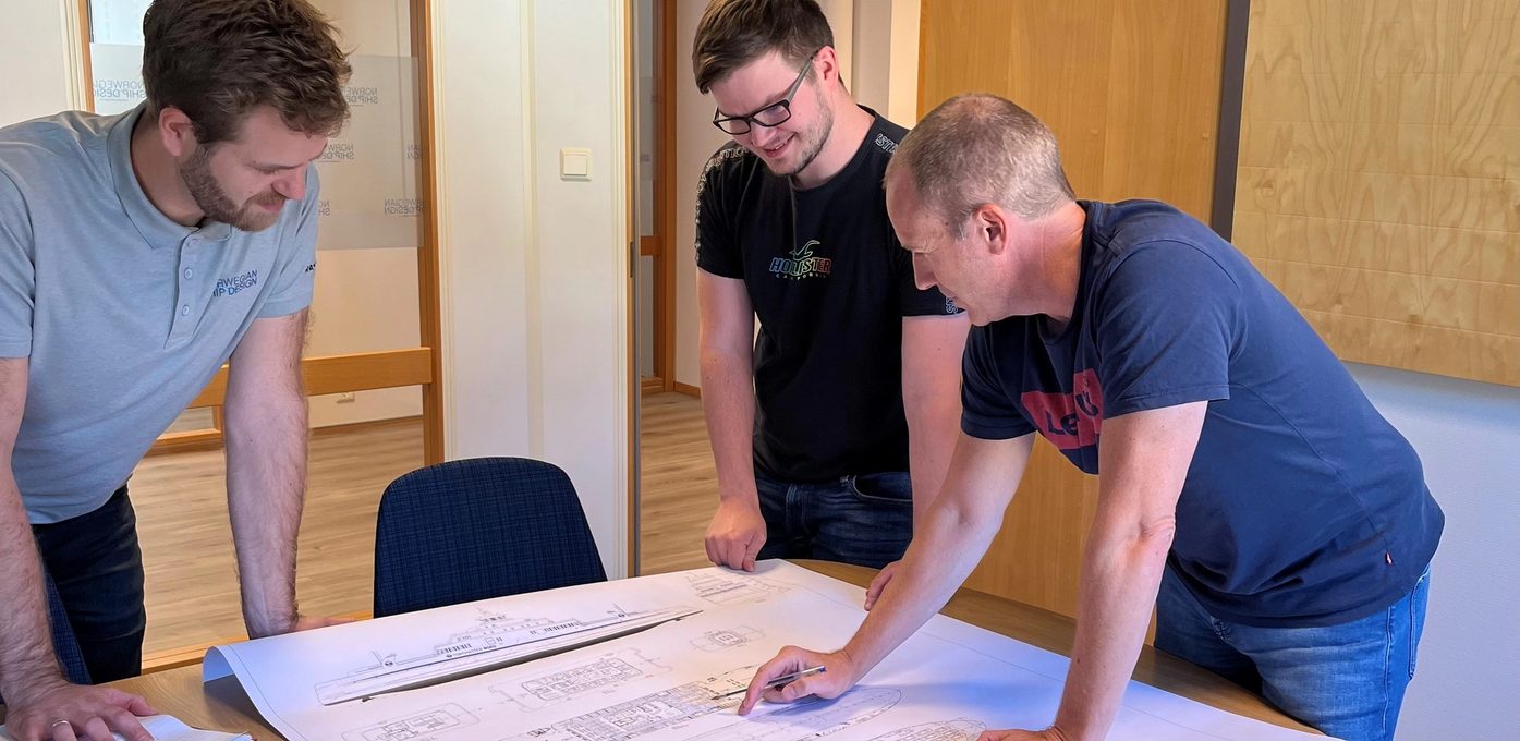 tre menn diskuterer skip