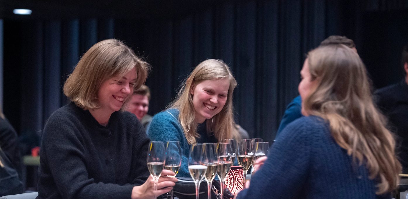 Tre kvinner ler på arrangement