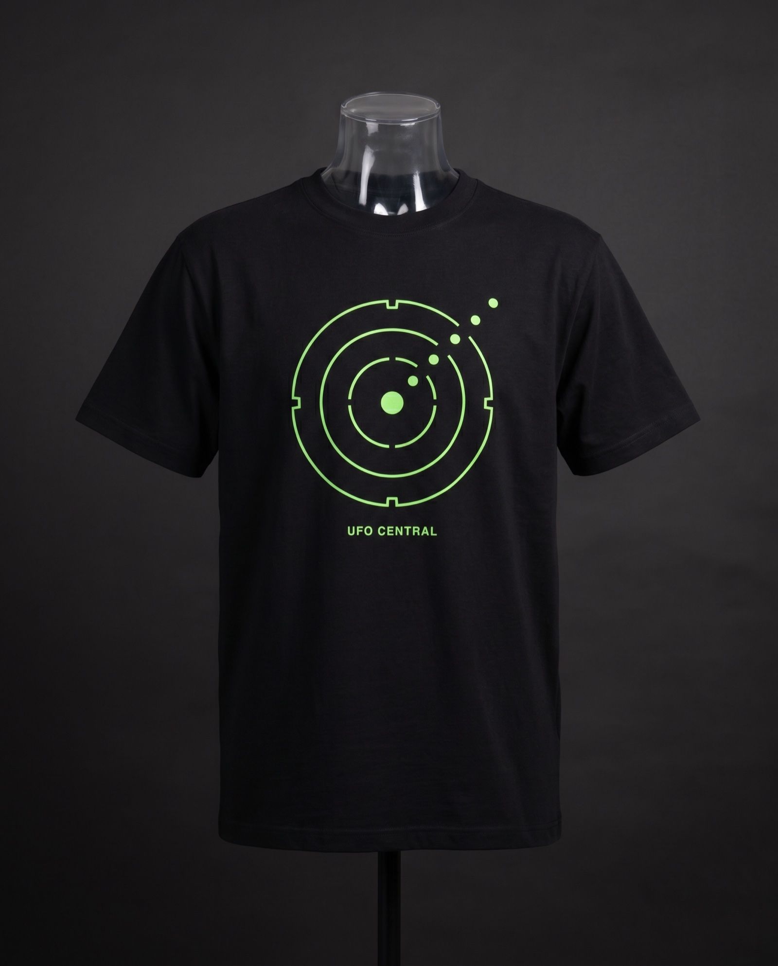 Mockup: black tee with the UFO Central radar glyph in phosphor lime