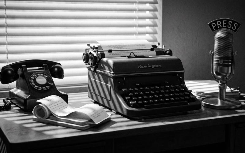 Illustration: a 1950s press-office desk with a typewriter and memo stacks
