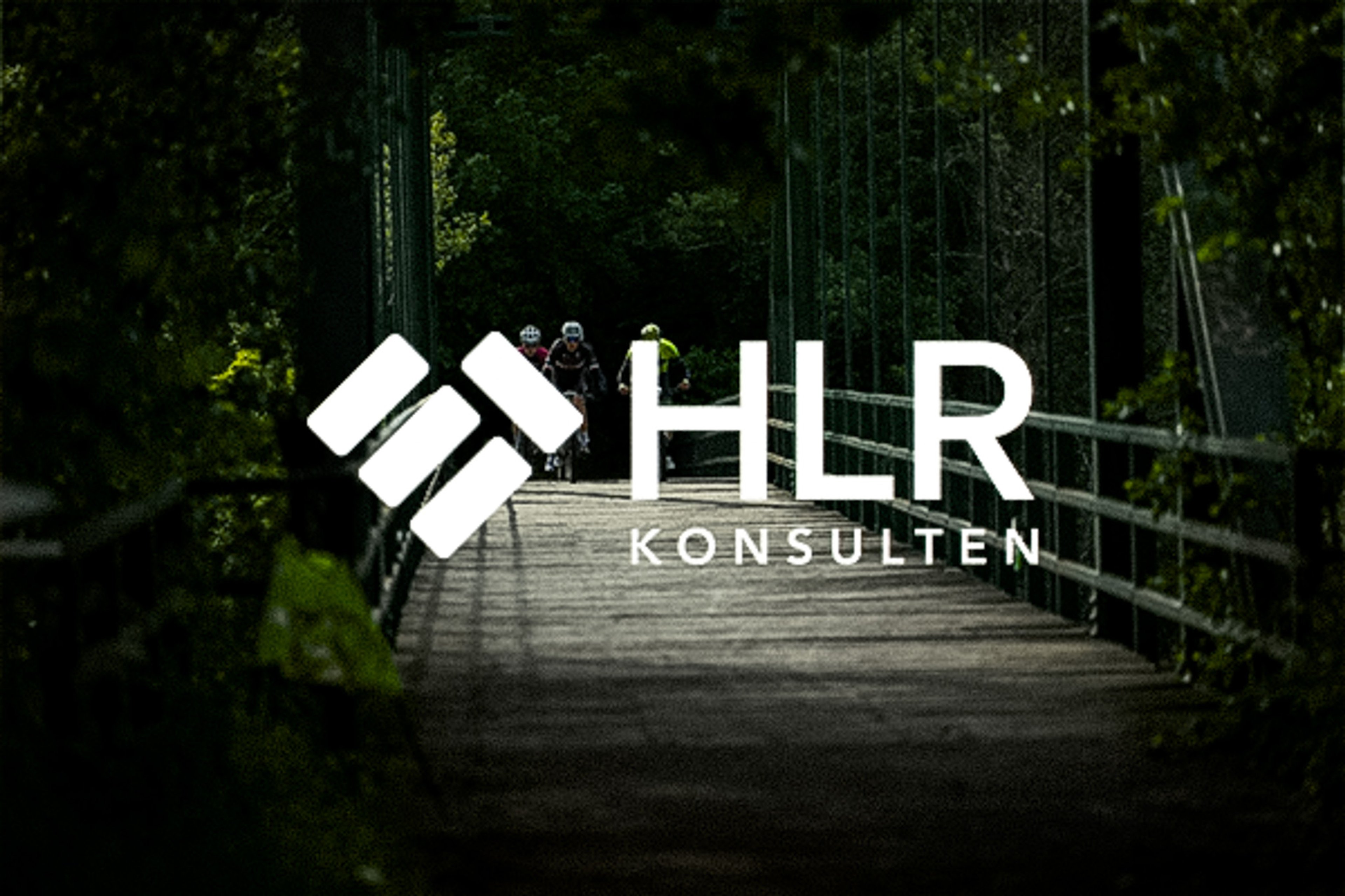 White HLR KONSULTEN logo over cyclists on a wooden bridge through green trees.