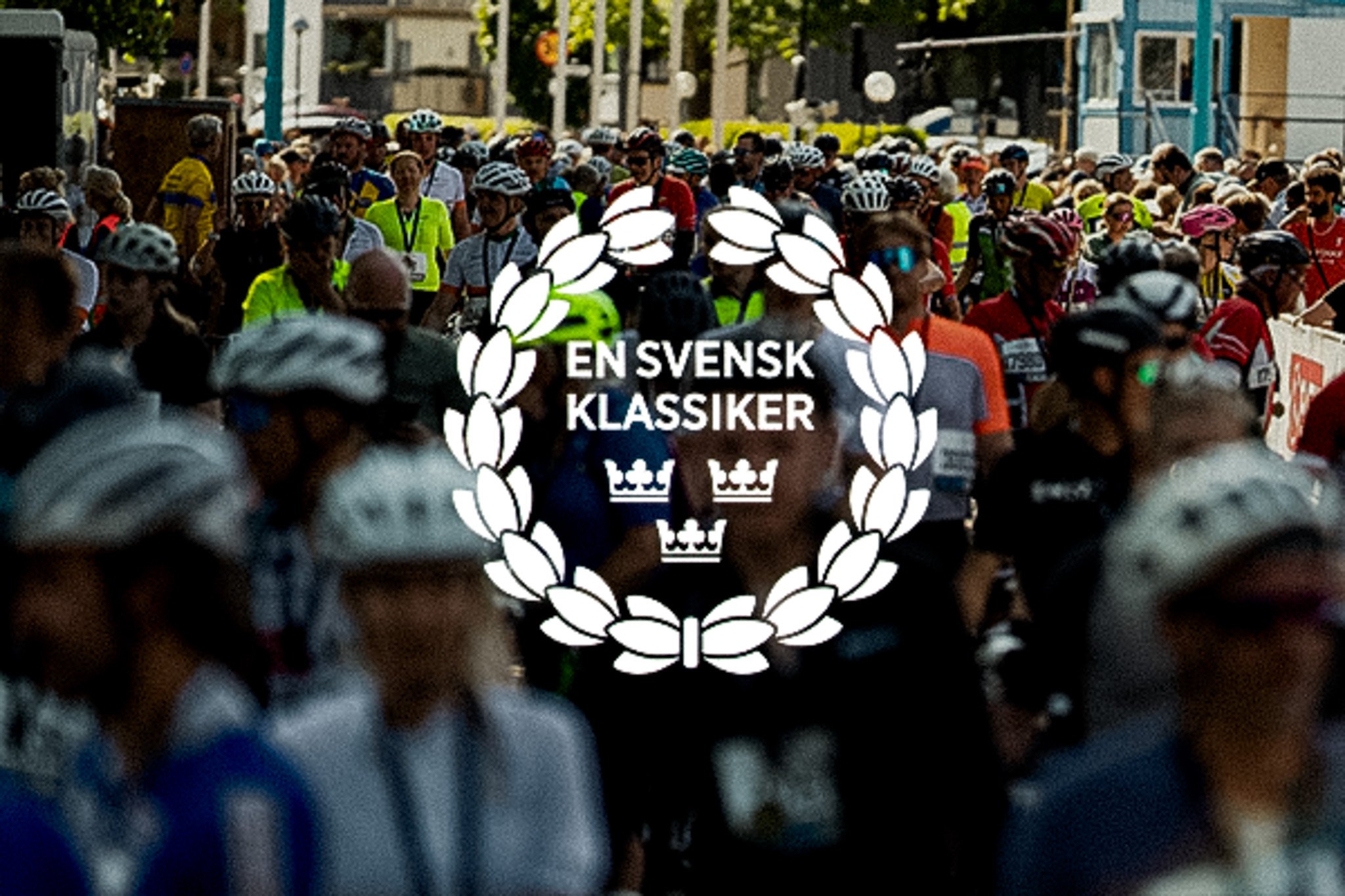 A crowd of people in cycling helmets with a white "EN SVENSK KLASSIKER" logo overlay.