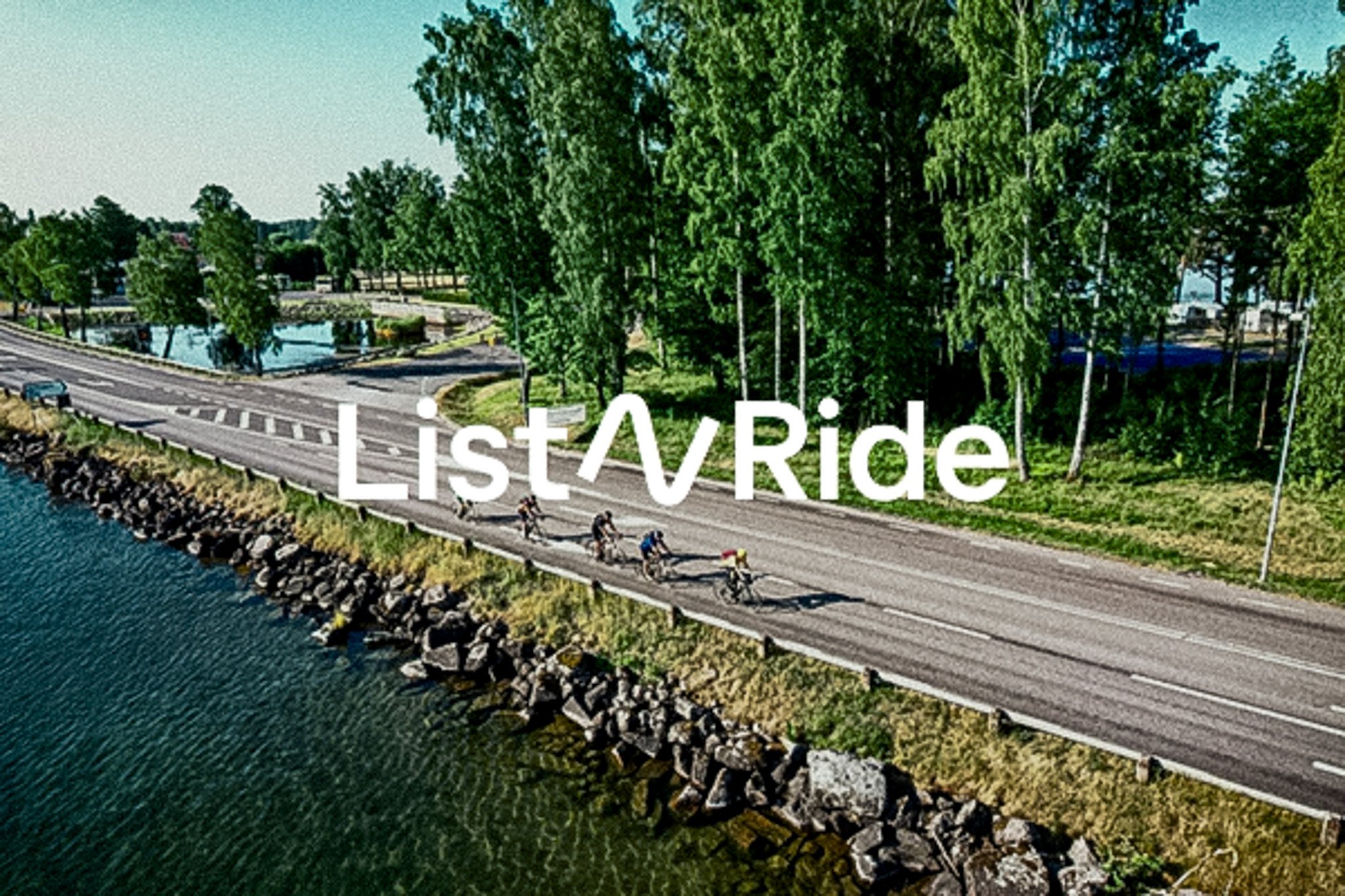 Aerial view of cyclists riding on a road next to a lake and trees, with 'List^Ride' text.
