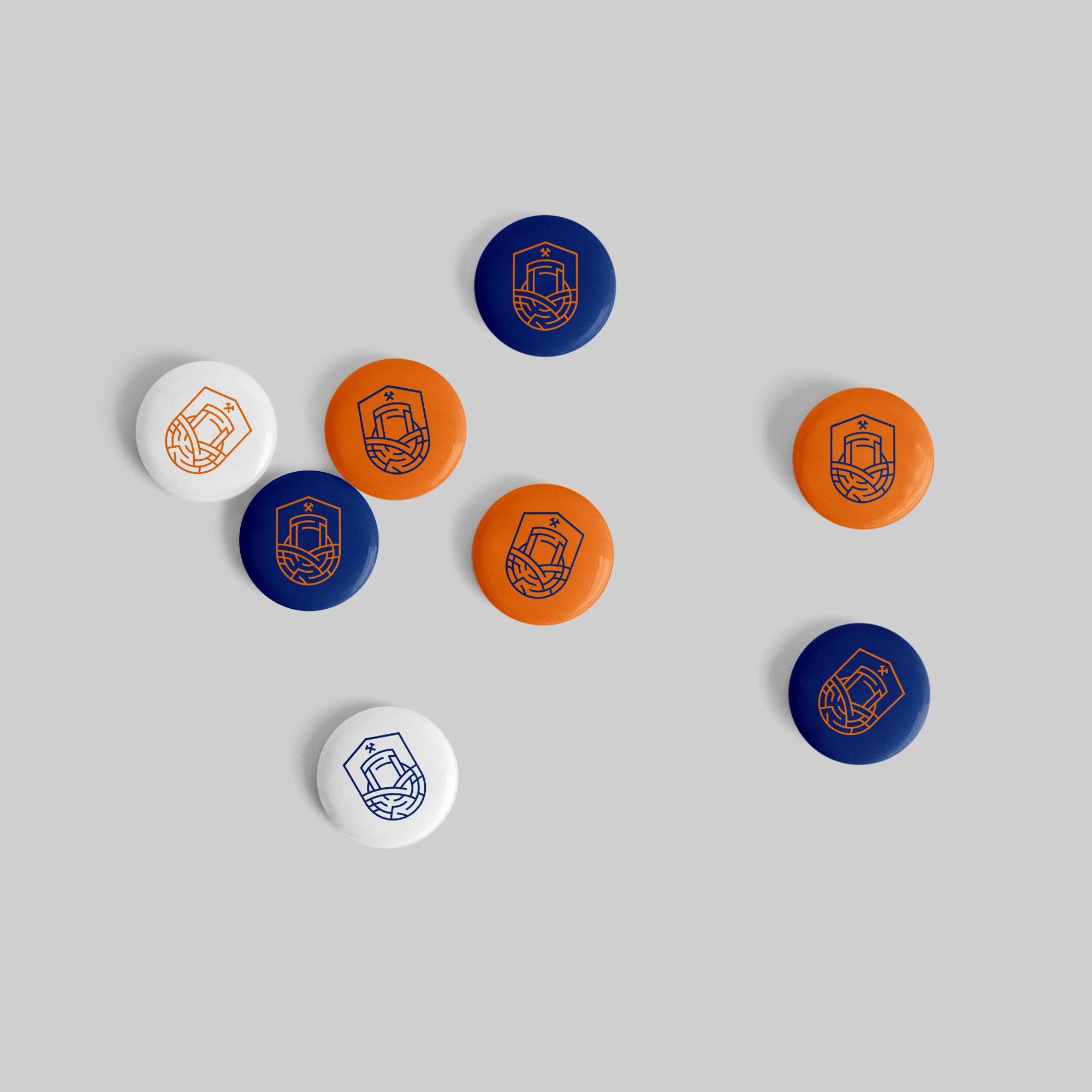 Eight round pins with the emblem in navy, orange and white