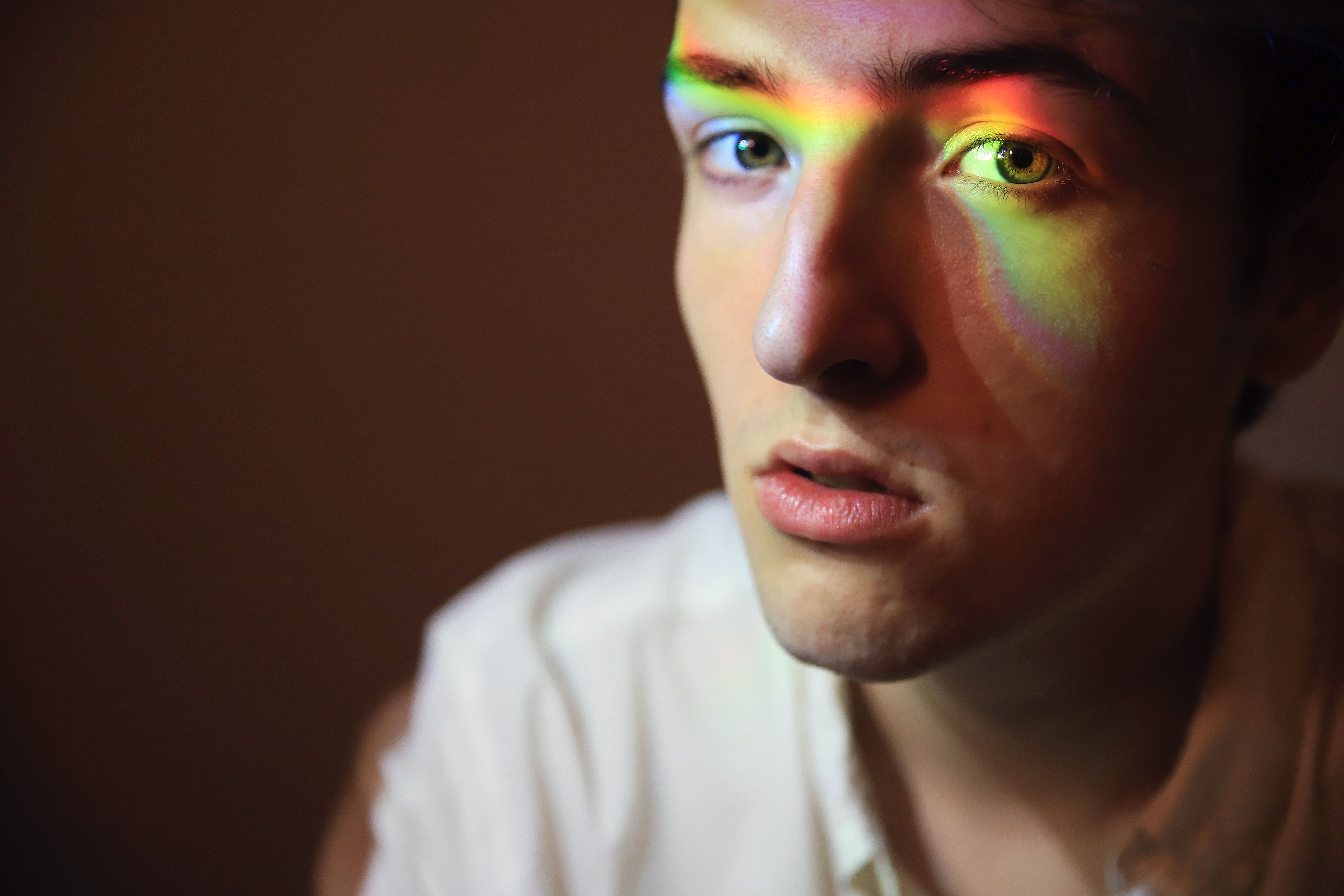 jongen met regenboogreflectie op gezicht