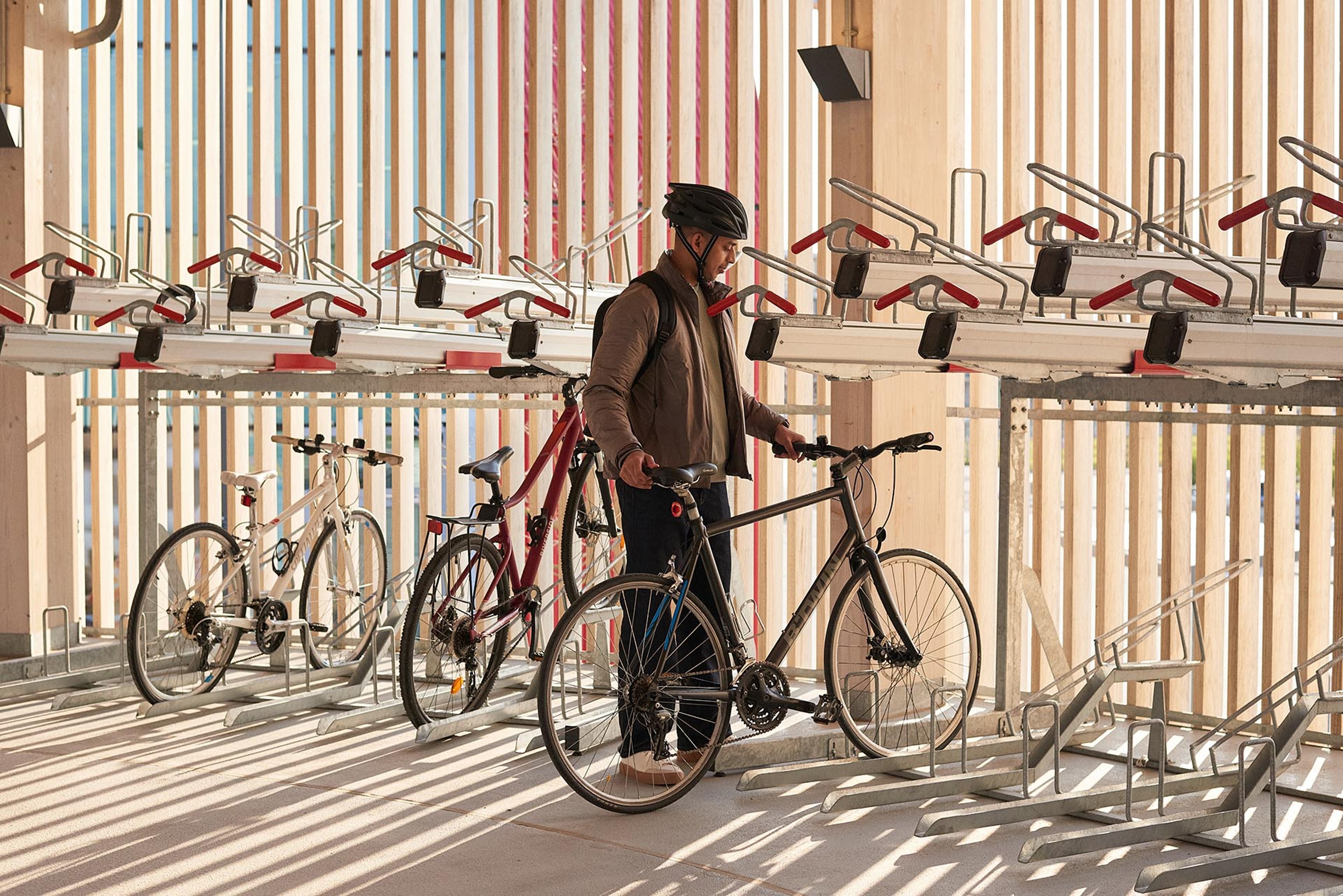 A man puts his bike away in the cycling pavilion