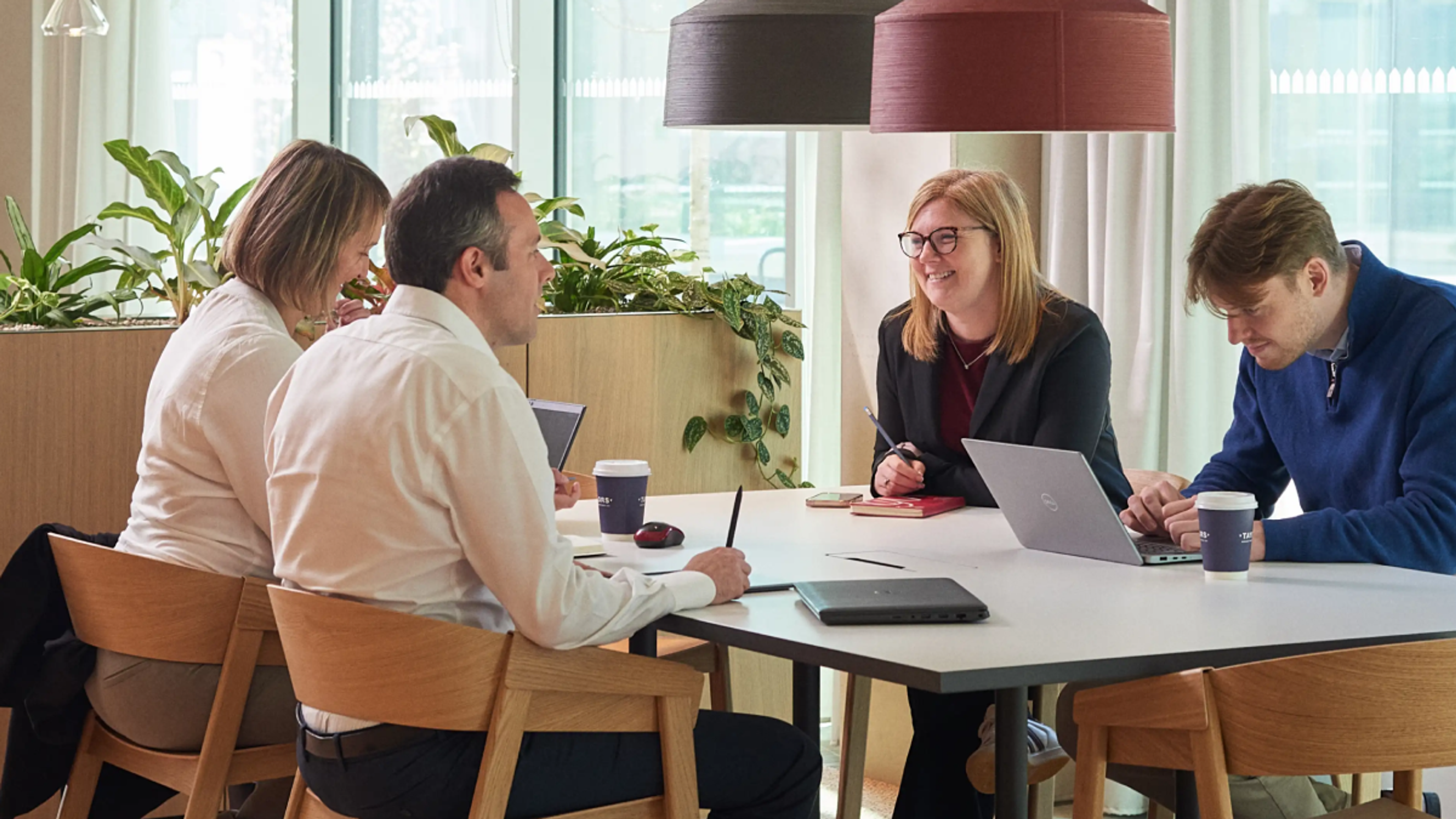 Four people have a meeting in a breakout space.