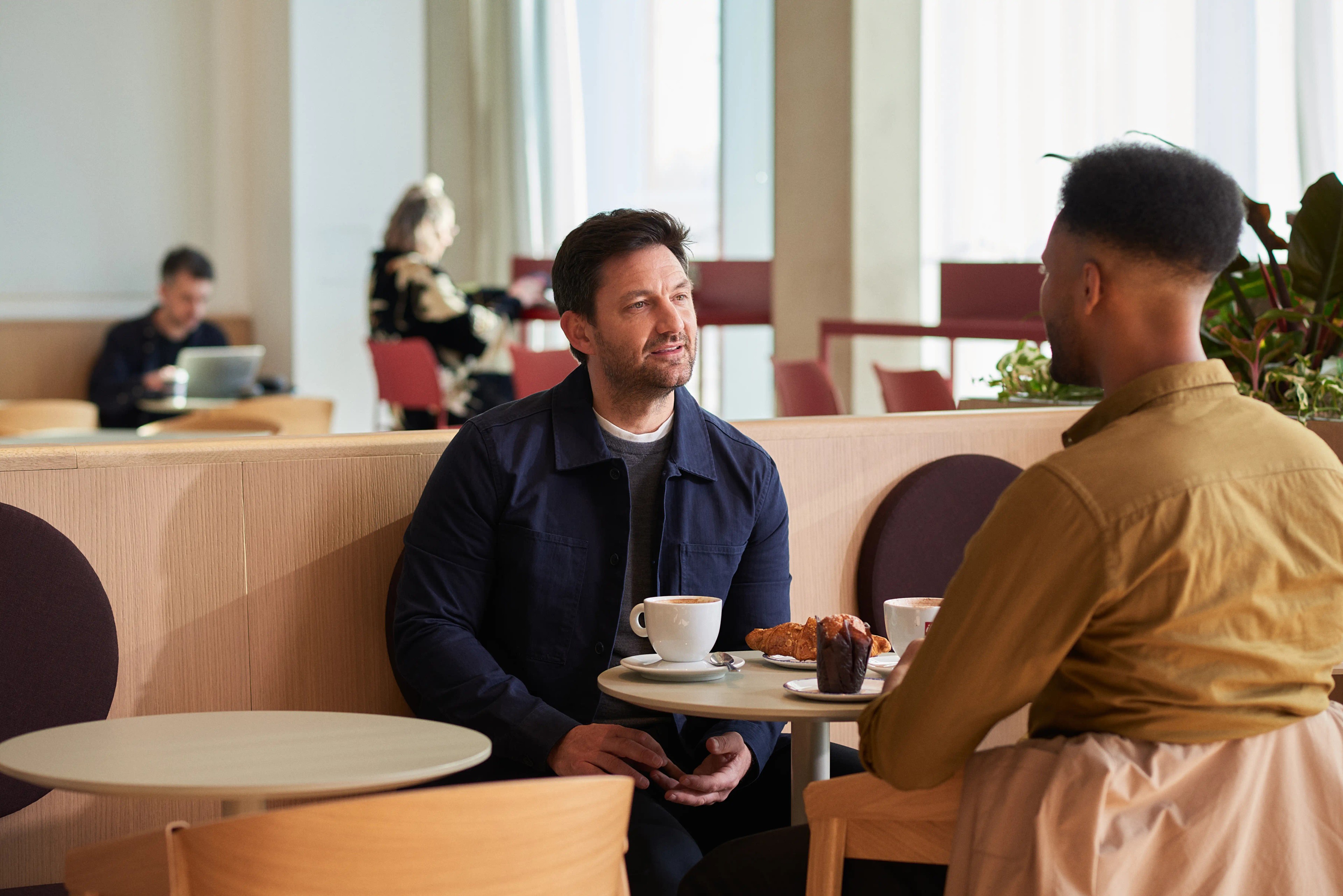 Two men enjoy a coffee at Oxford North. 