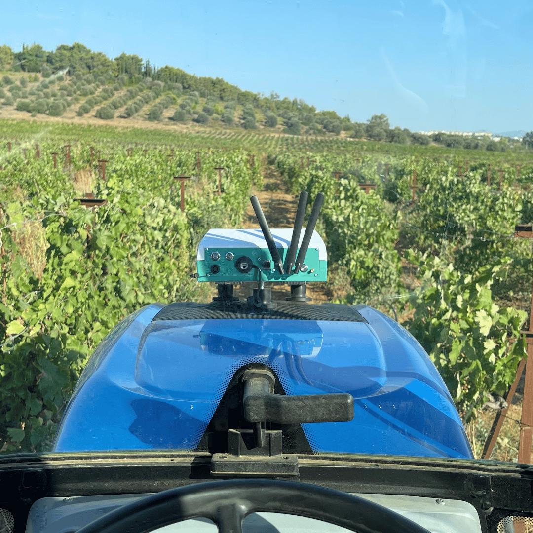 Viewer-equipped tractor moving through vineyard rows