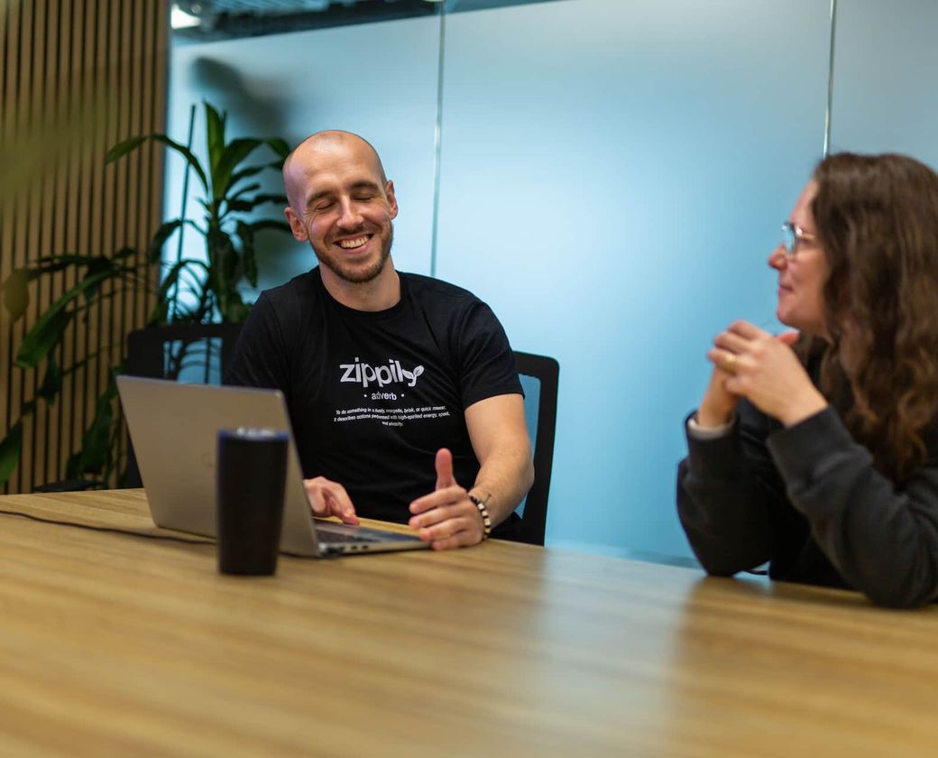Zippily team members discussing work at a laptop