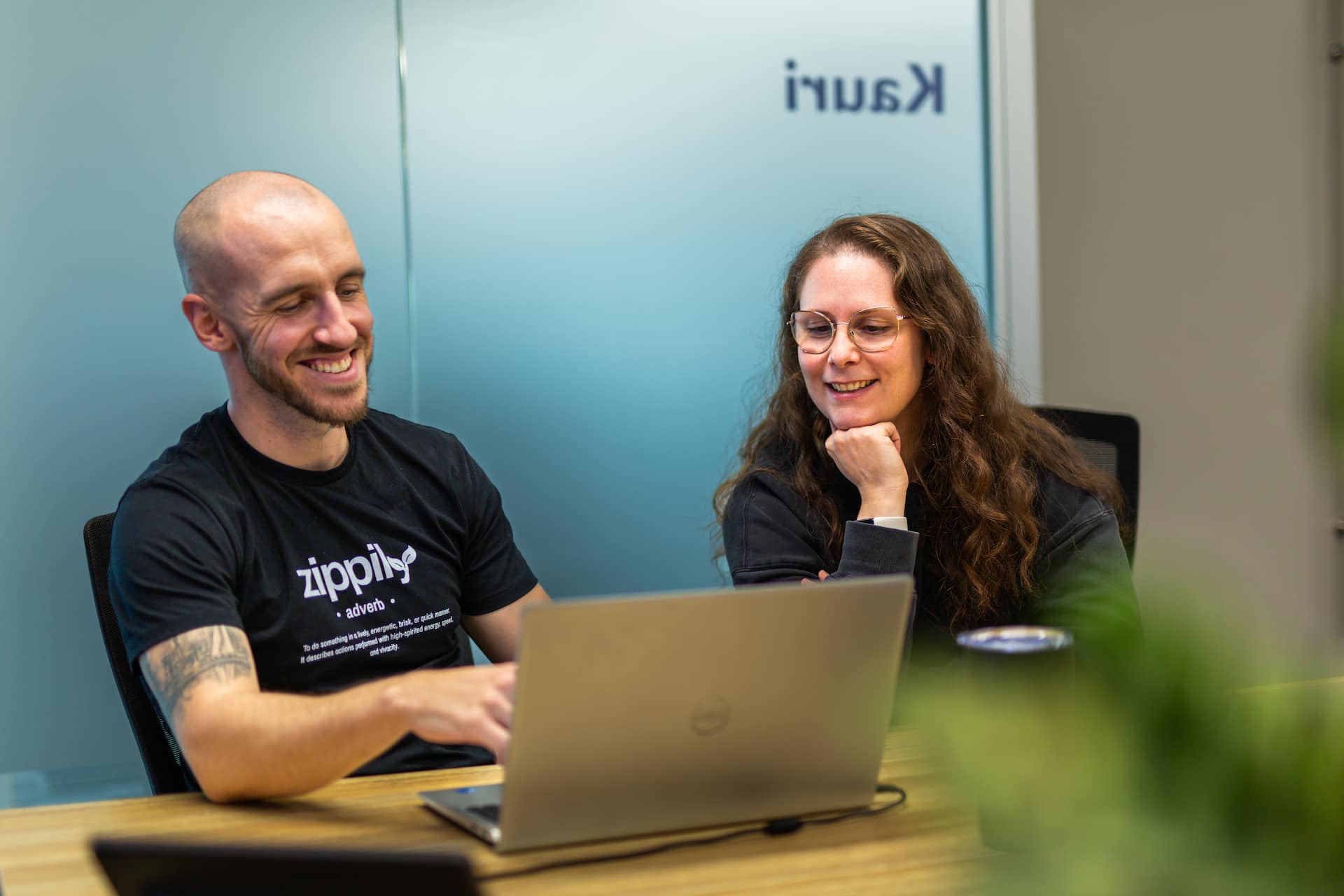 Two Zippily team members working together at a laptop