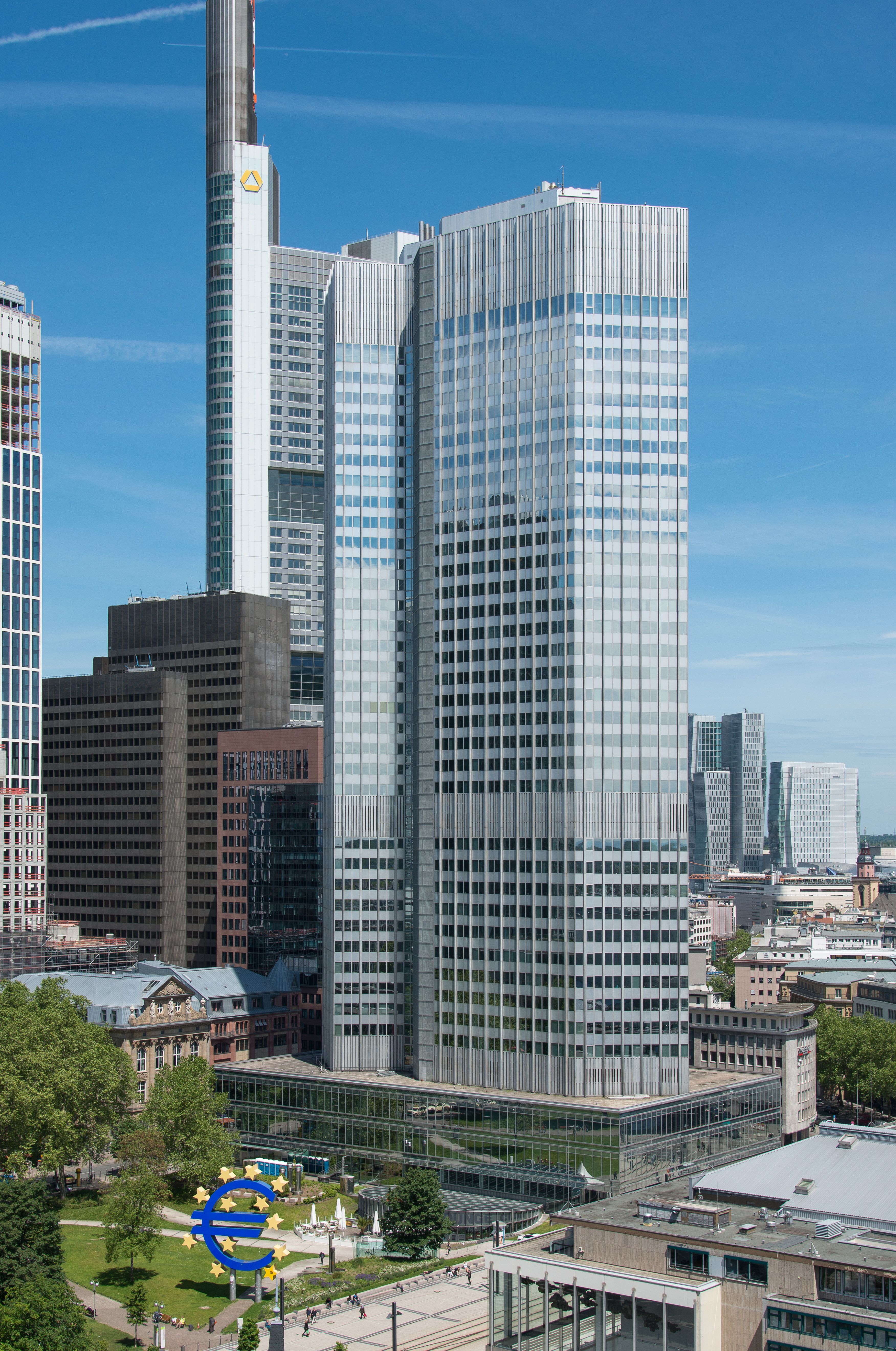 The Eurotower in Frankfurt with the euro sign sculpture in front of it.