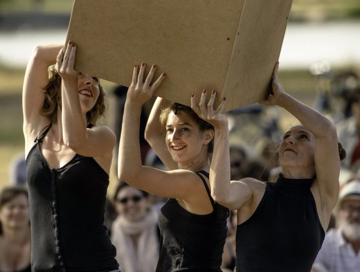 Les trois interprètes portent une boîte en carton