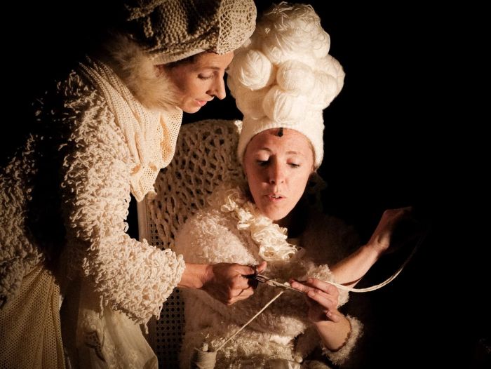 Deux interprètes en costumes tricotent