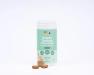 Buddy & Lola Super Tummy Daily Chews tub on a white background, with three square brown chews placed in front. The mint green label describes the product as Advanced Pre & Probiotics in a chicken and bacon flavouring, plant-based formula, with 60 soft chews per tub. Benefits listed include aiding stool consistency, supporting digestive health, and promoting overall health and vitality.