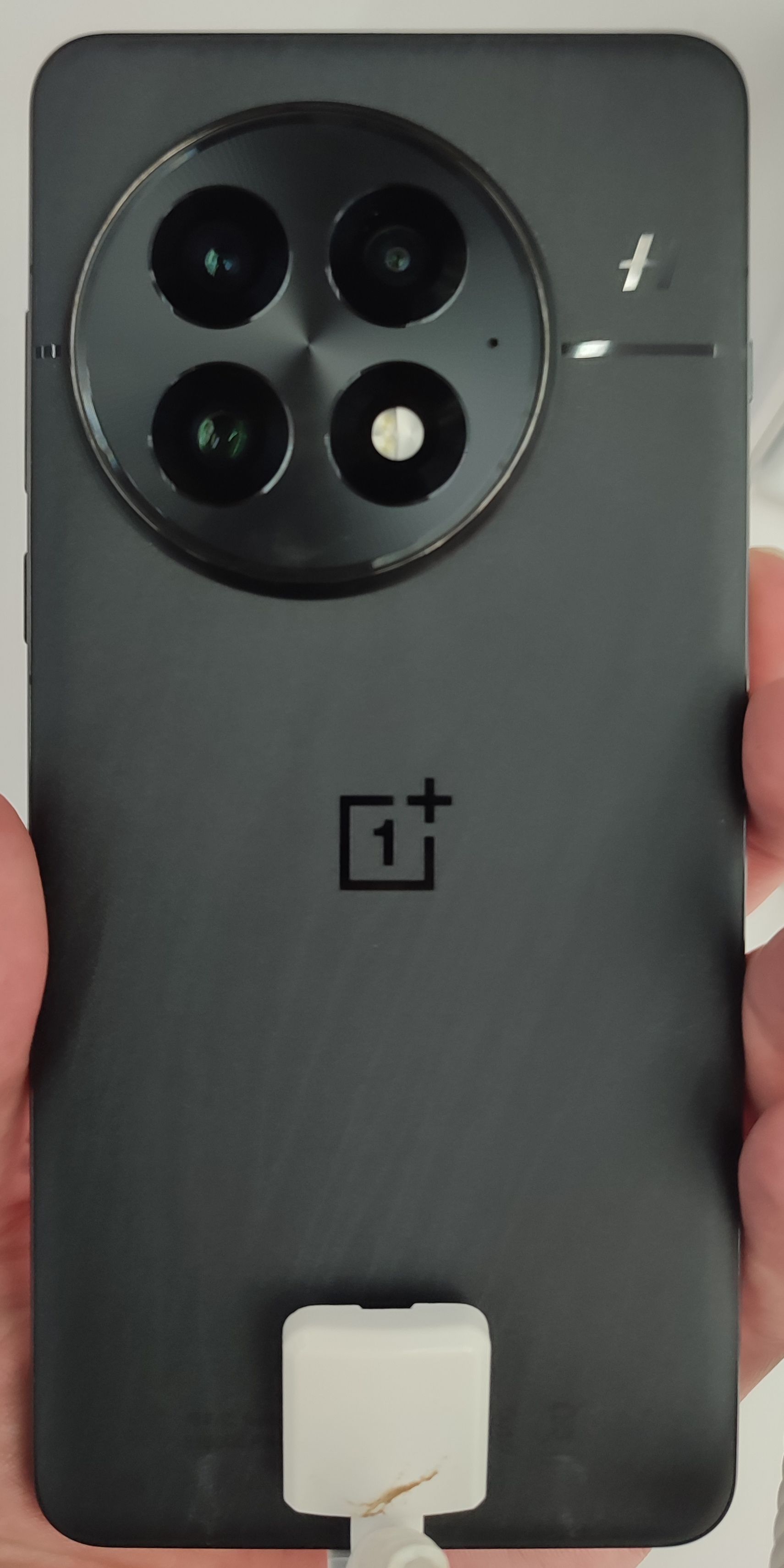 OnePlus 14 smartphone showing the rear curved finish and circular camera arrangement. Photo: Maksdroider (CC BY-SA 4.0).