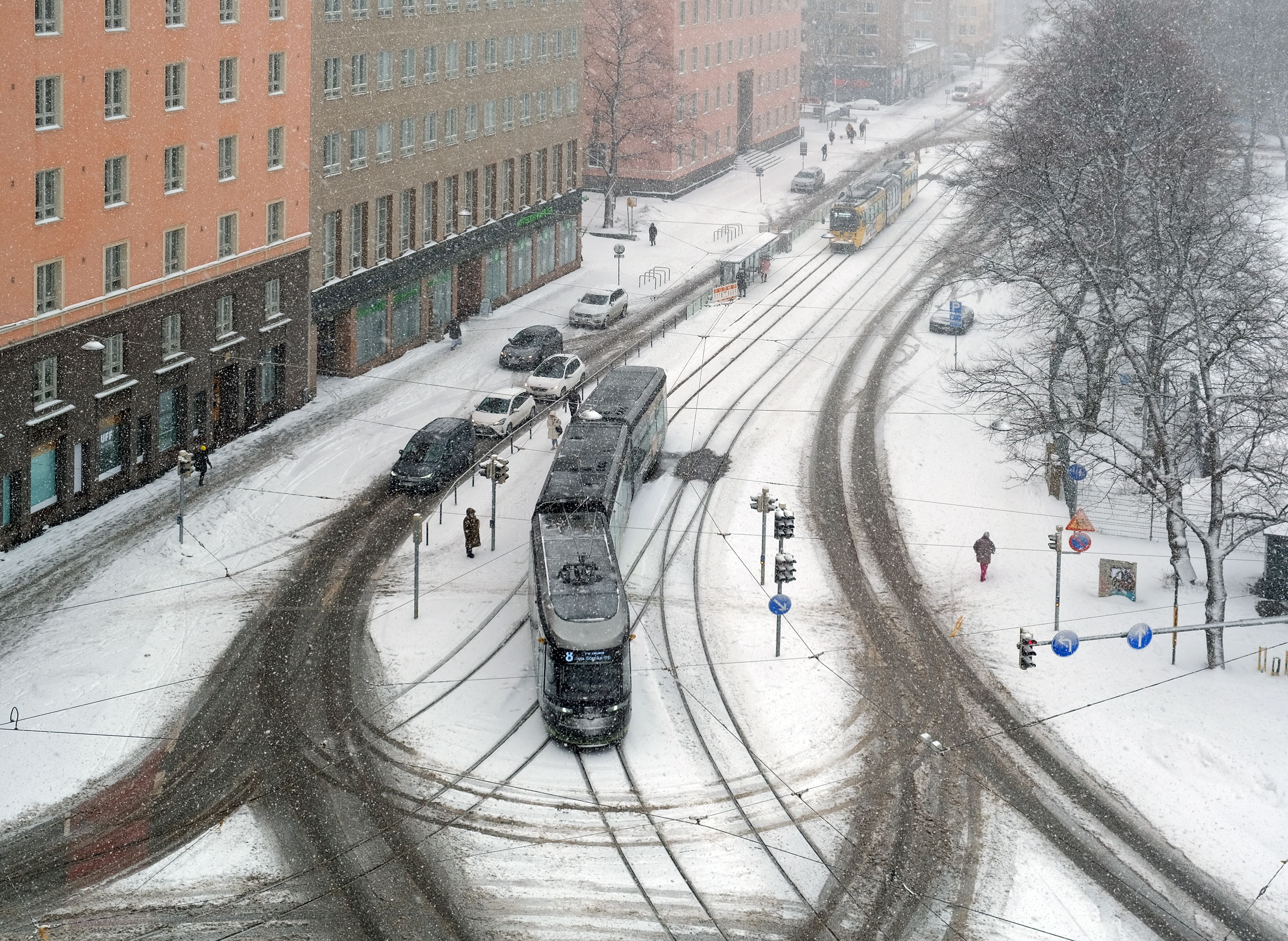 A tram navigates snowy streets in central Helsinki. Finland has topped the World Happiness Report for seven consecutive years, yet daily life looks remarkably subdued and quiet. (Photo: Kallerna / Wikimedia Commons / CC BY-SA 4.0)