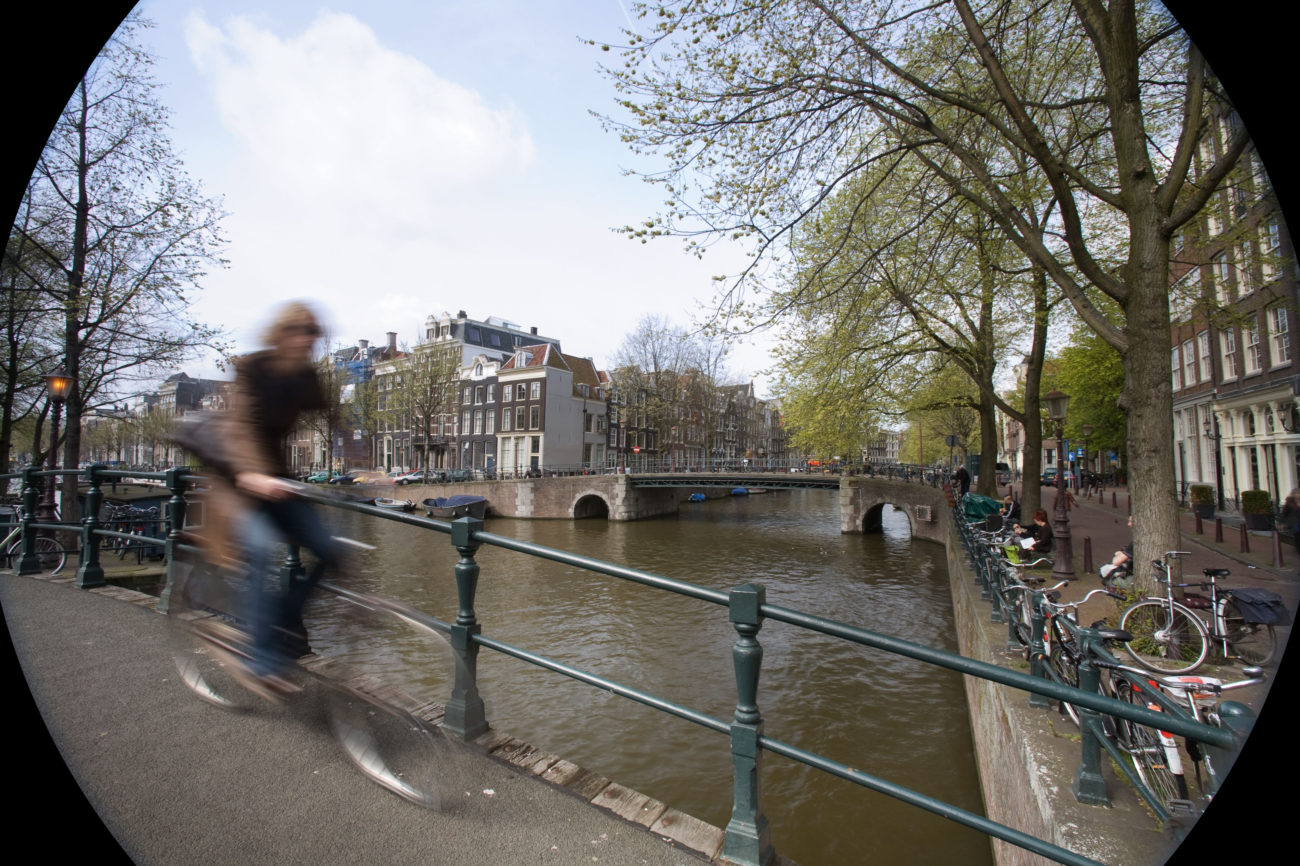 Bicycles along a canal in Amsterdam. The Netherlands consistently ranks near the top of OECD well-being indexes, driven by flexible working hours and the highest child life-satisfaction scores in Europe. (Photo: Jorge Royan / Wikimedia Commons / CC BY-SA 3.0)