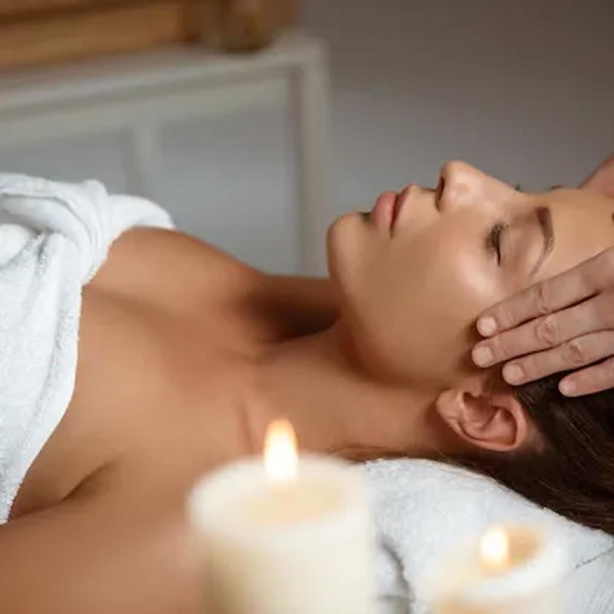 Mum ışığında baş masajı alan misafir