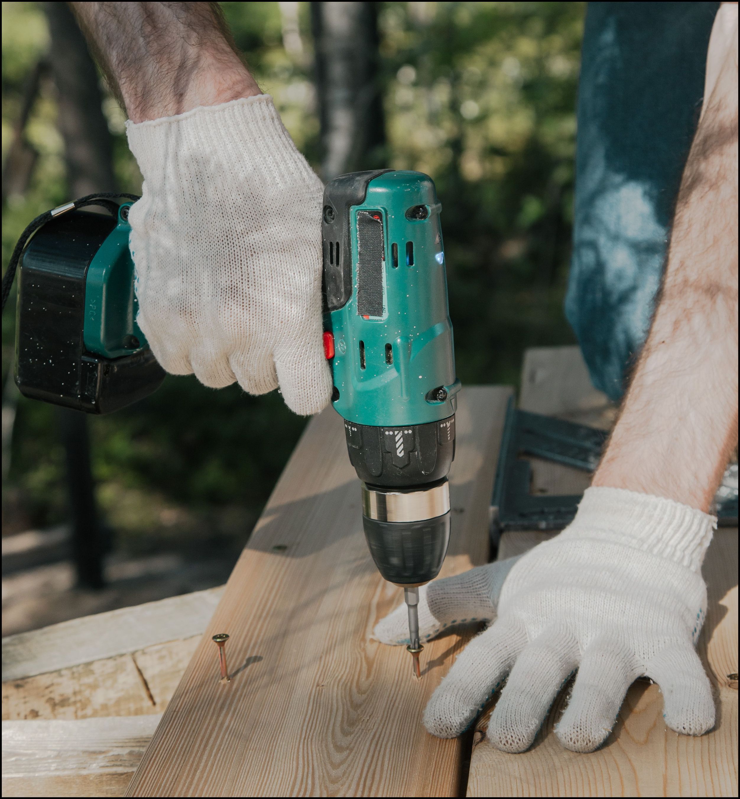hands drilling screws into wood