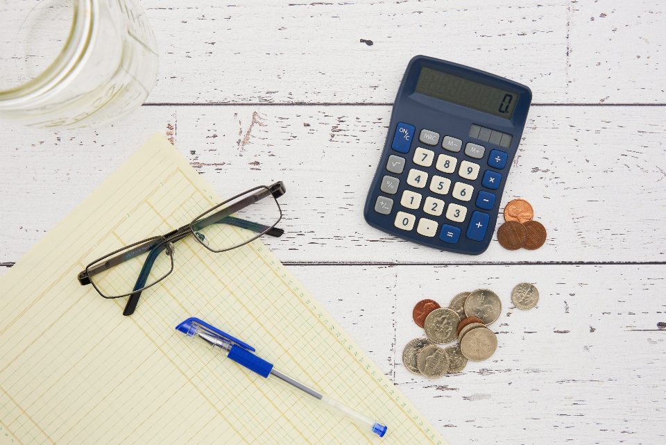 Calculator, glasses and financial papers on a desk