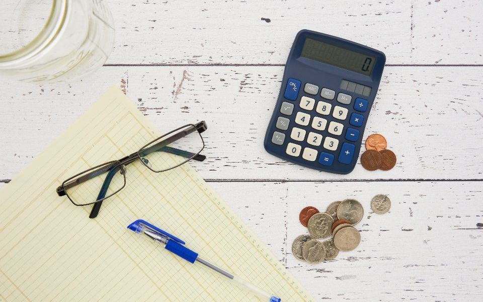 Calculator, glasses and financial papers on a desk