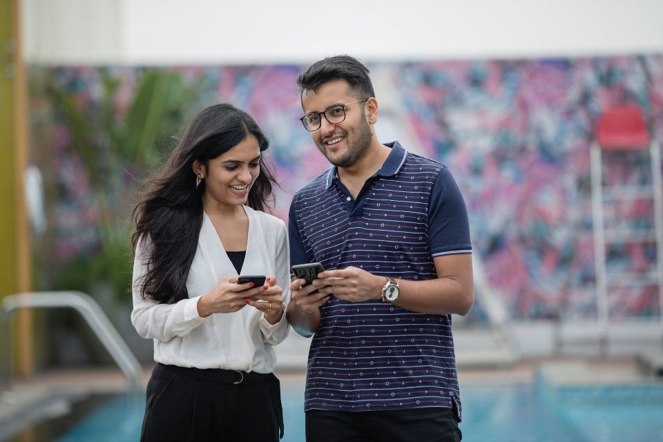 Two colleagues smiling at a phone
