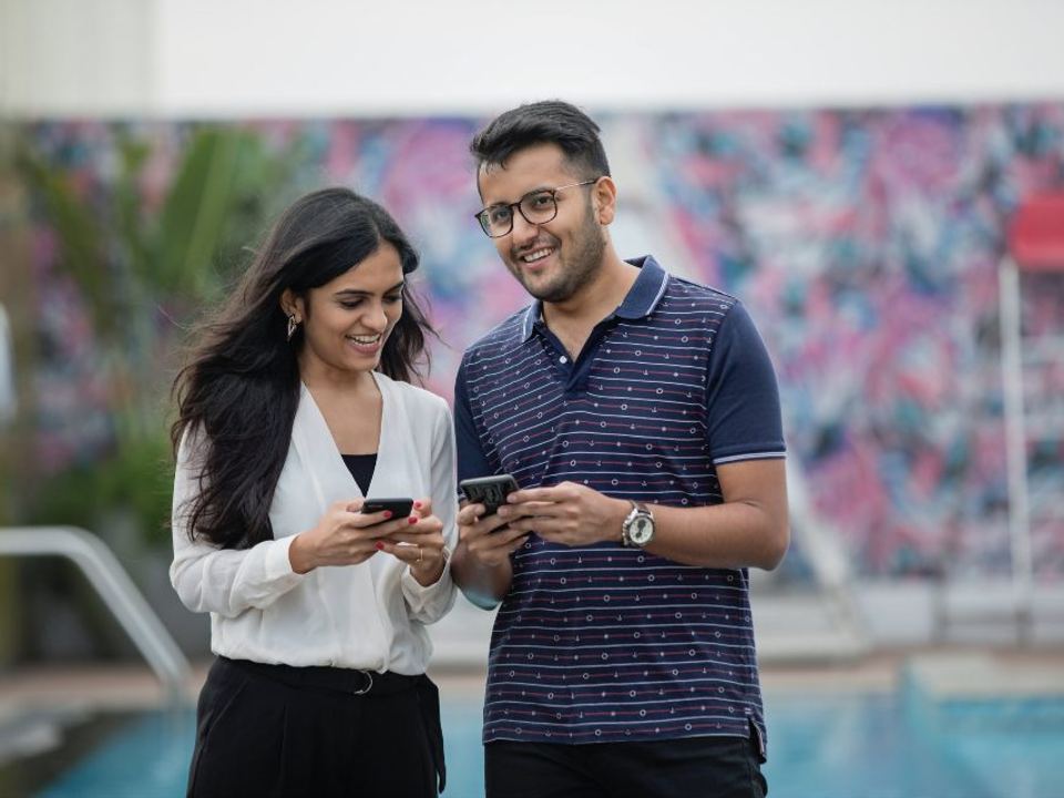 Two colleagues smiling at a phone