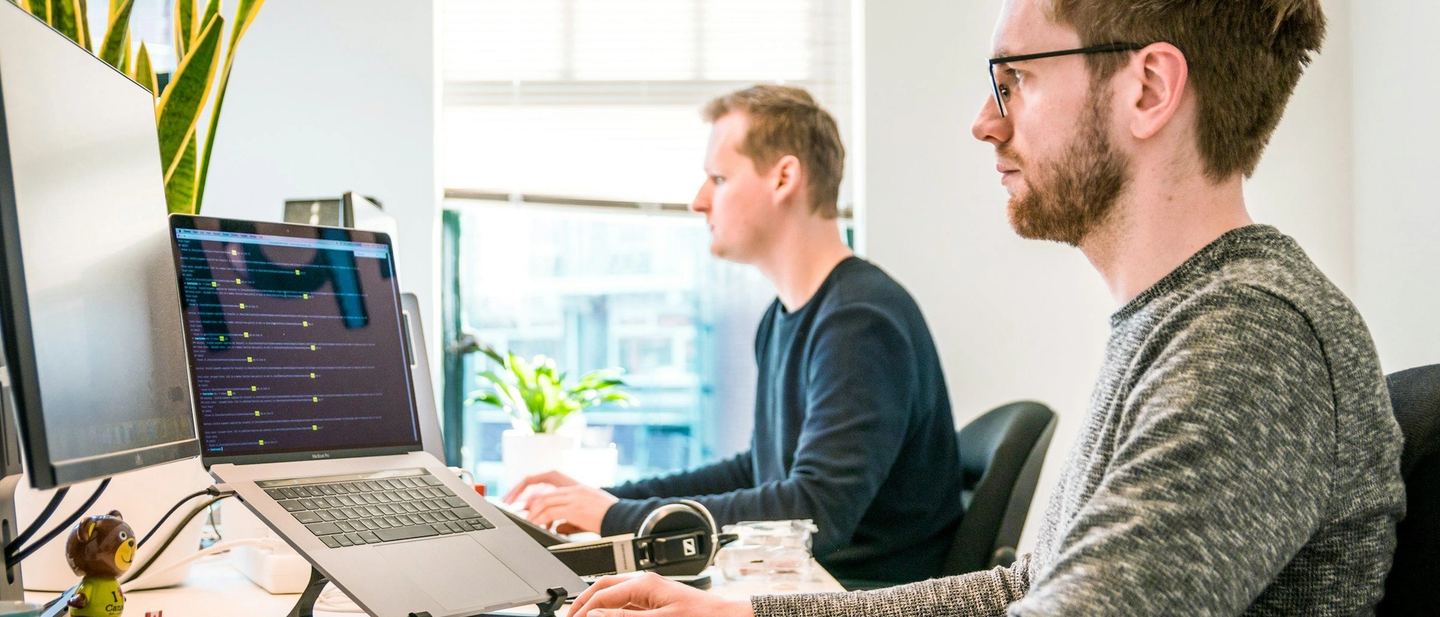 Two developers discussing work at a computer