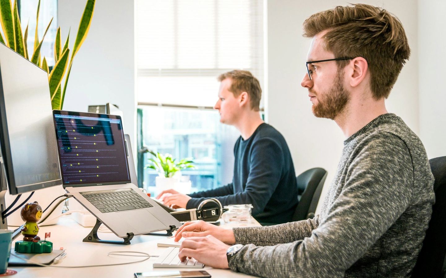 Two developers discussing work at a computer