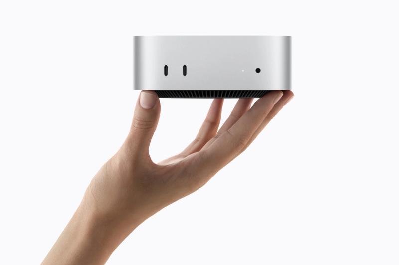 Eine Hand hält den neuen Mac mini mit M6, dessen Gehäuse kaum größer als die Handfläche ist