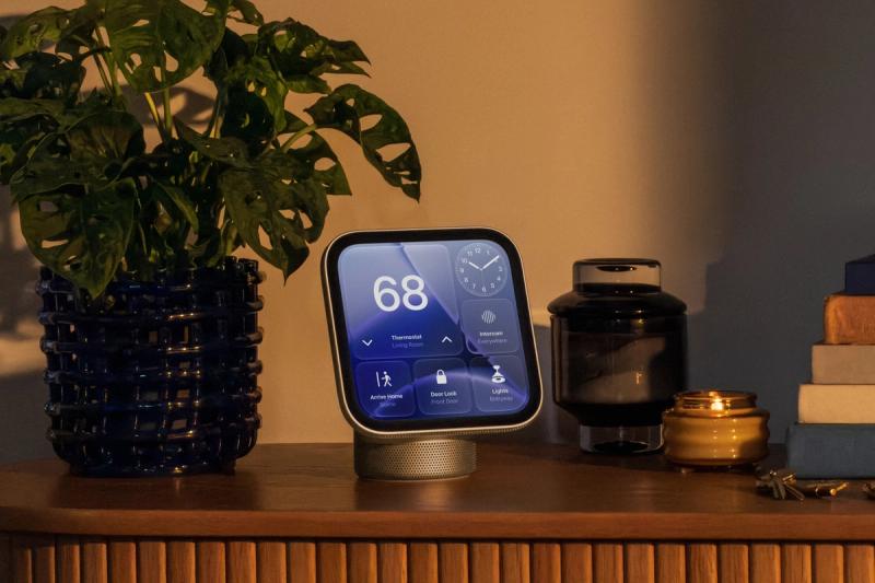 HomeView auf einem Holzsideboard neben einer Pflanze, der Bildschirm zeigt eine Thermostat-Anzeige und Smart-Home-Schalter