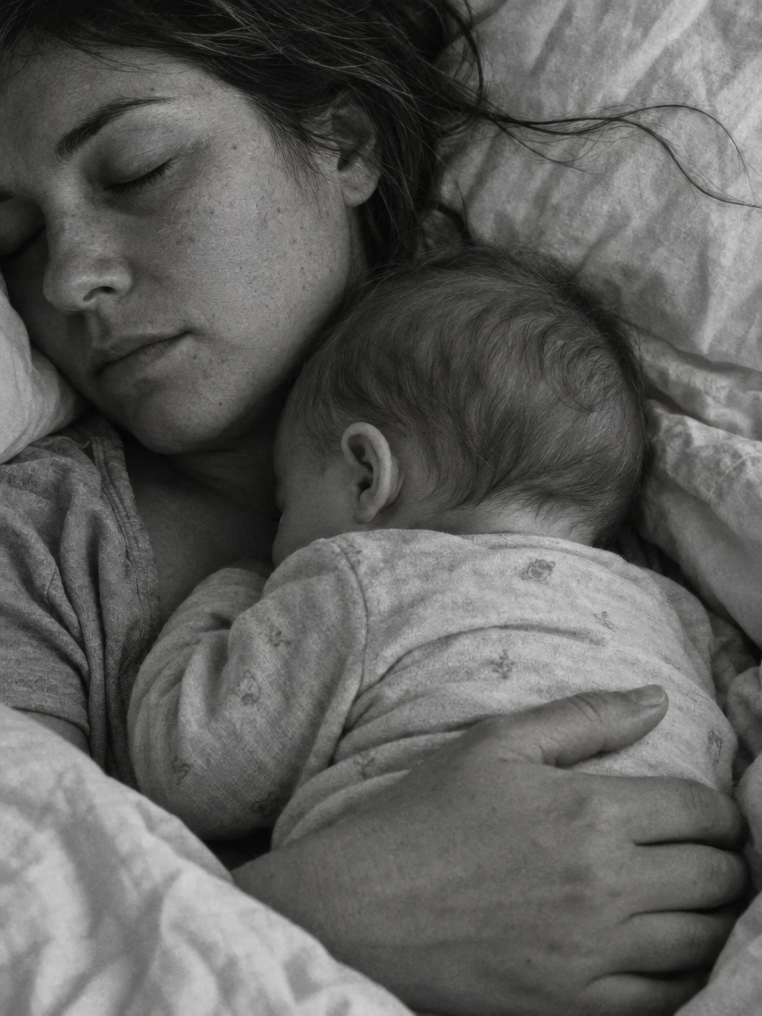 Madre y bebé durmiendo abrazados, en blanco y negro