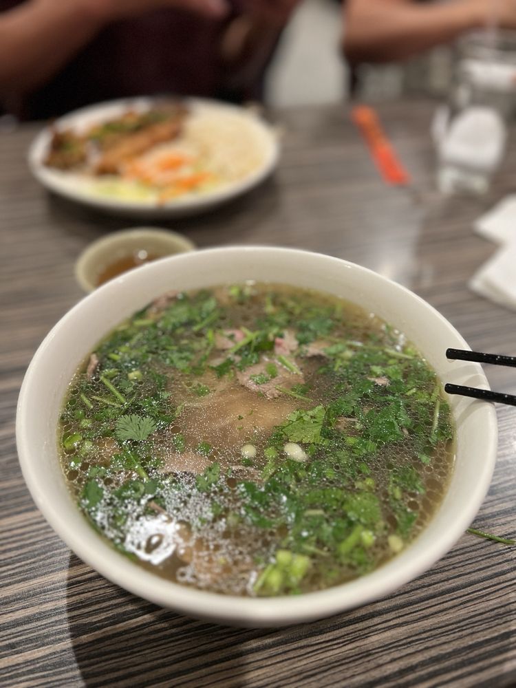 Bowl of beef pho with tender filet mignon slices under cilantro and green onion