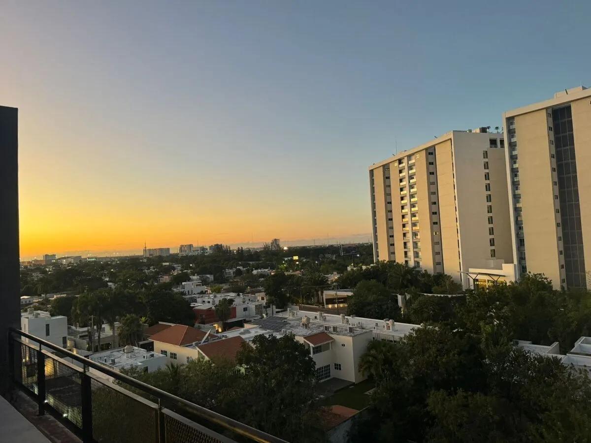 Paisaje urbano con una mezcla de edificios de departamentos y varias torres modernas de gran altura en la distancia.
