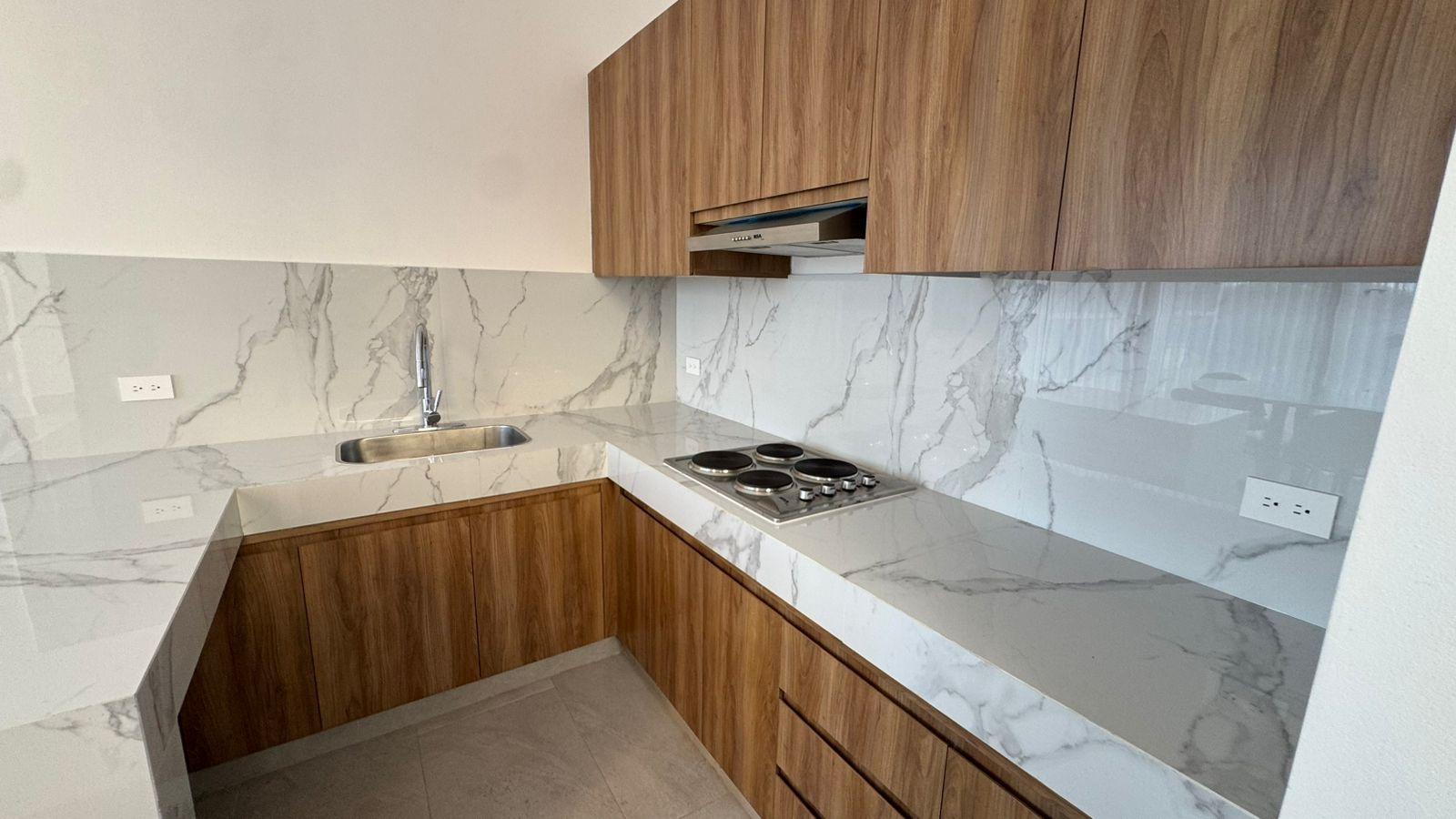 Cocina moderna y minimalista con una combinación de gabinetes de madera y encimeras estilo mármol blanco.