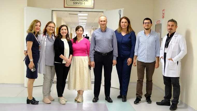 Çocuk hastalıkları servisi önünde bir grup sağlık çalışanı poz veriyor.