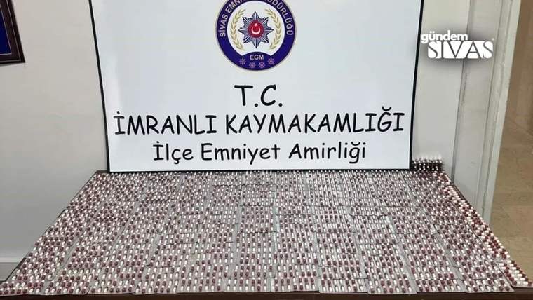 Bir masanın üzerinde sıralanmış çok sayıda uyuşturucu madde ve arka planda İmranlı Kaymakamlığı tabelası.