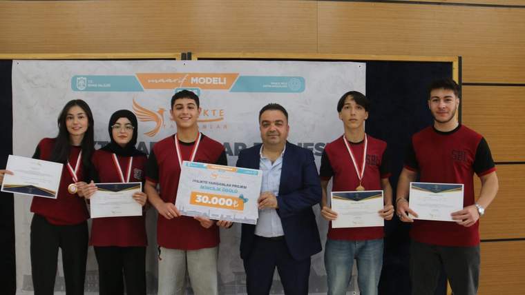 Ödül alan gençler, sertifikalarını ve ödülünü tutarak poz veriyor.
