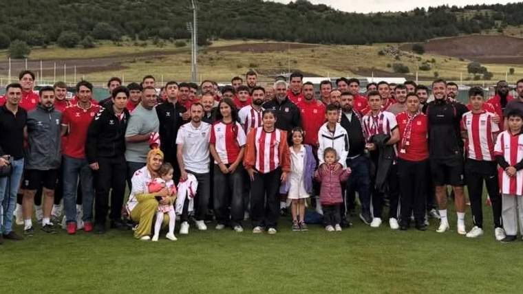 Futbol takımı ve taraftarlar, Kayseri'de bir araya gelerek poz veriyor.