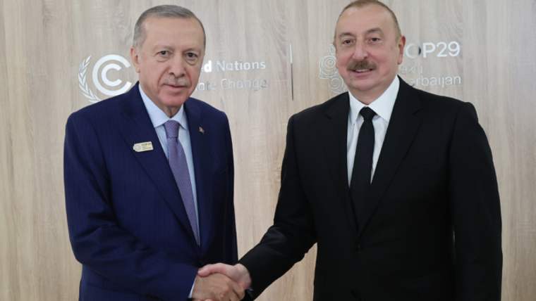 Cumhurbaşkanı Erdoğan ve Azerbaycan Cumhurbaşkanı Aliyev, el sıkışarak poz veriyorlar.