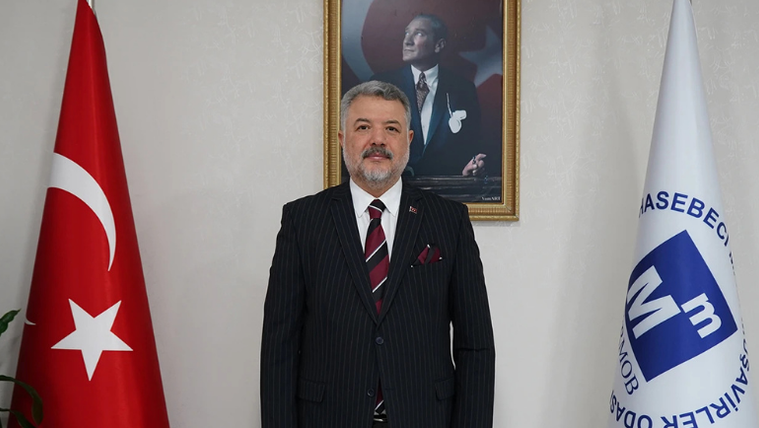 Kahramanmaraş Mali Müşavirler Odası'nın logosu ve Türk bayrağı ile bir kişi, arka planda Atatürk portresiyle birlikte duruyor.
