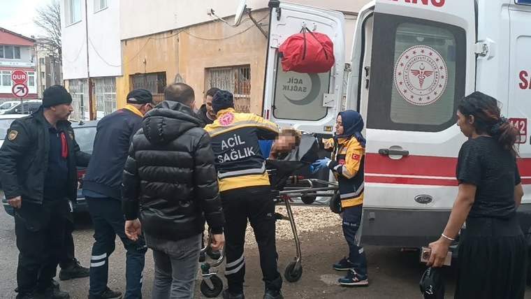 Ambulansın önünde sağlık ekipleri, yaralı bir kişiyi sedye ile taşıyor.
