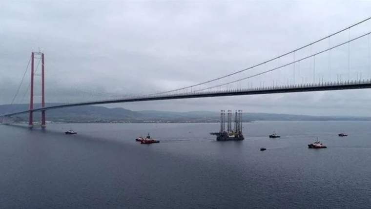 Çanakkale Boğazı'nda bir köprü altında, çeşitli kurtarma ve destek gemileri su üzerinde hareket ediyor.