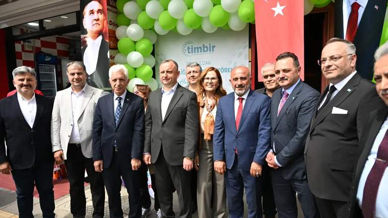 Açılışta bir araya gelen kalabalık, arka planda Türk bayrakları ve balonlar ile birlikte poz veriyor.