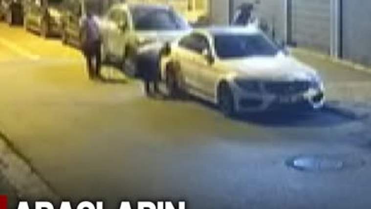 İki kişi, park halindeki araçların lastiklerini patlatıyor.