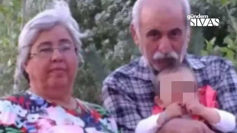 Açık havada yaşlı bir kadın ve bıyıklı bir erkek, yüzü bulanıklaştırılmış bir bebeği tutuyor.