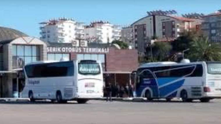 Serik Otobüs Terminali yazılı binanın önünde iki büyük yolcu otobüsü ve çevrede apartmanlar görülüyor.