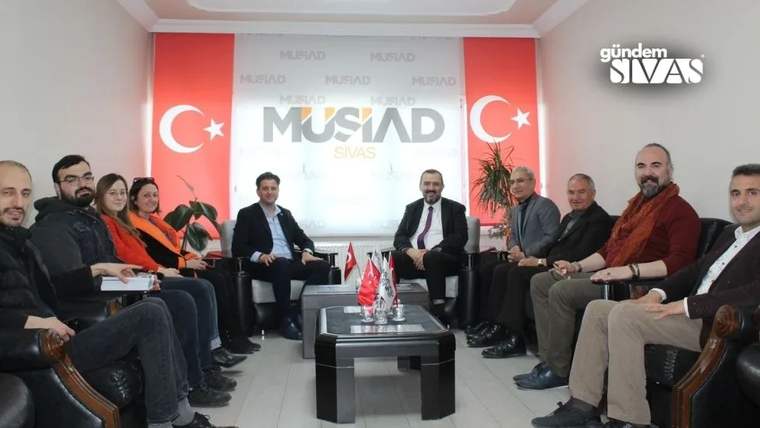 MÜSİAD Sivas ofisinde bir grup insan, masanın etrafında oturuyor.