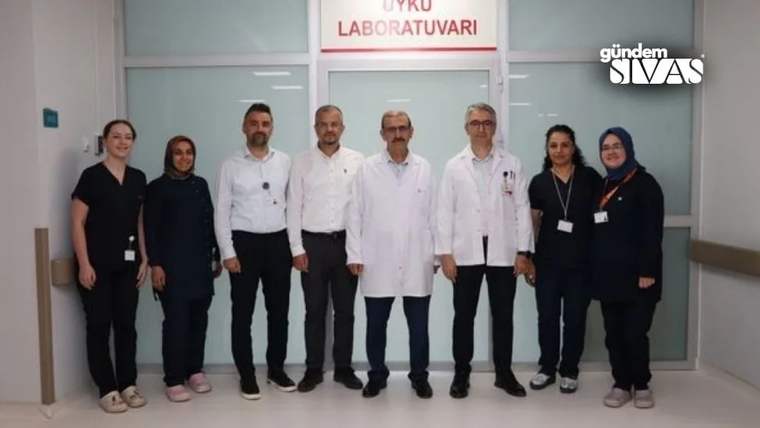 Beyaz önlük giymiş doktorlar ve hemşireler, Uyku Laboratuvarı tabelasının önünde duruyor.